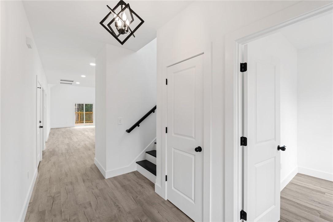 Image 3: A well-lit hallway with light wood flooring connec