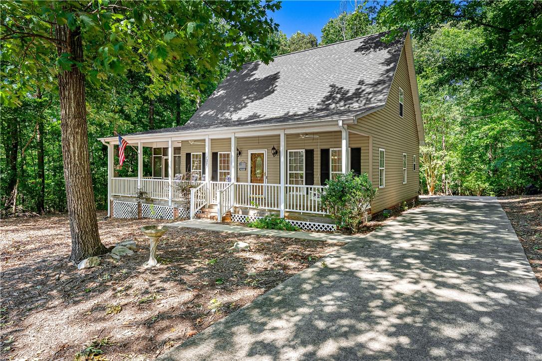 Image 1: A welcoming front porch extends across this charmi