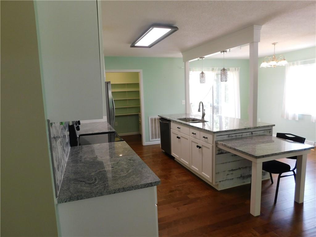 Image 3: A gourmet kitchen boasts sleek granite counters an