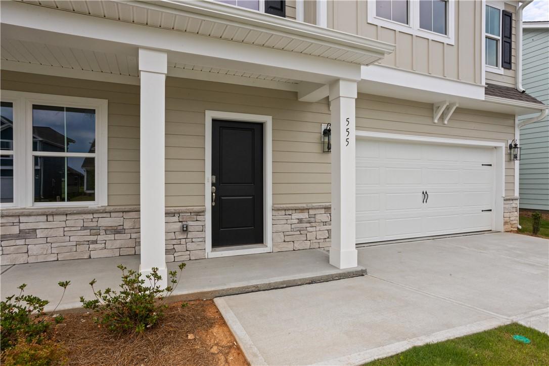 Image 3: A welcoming covered porch and garage entrance feat