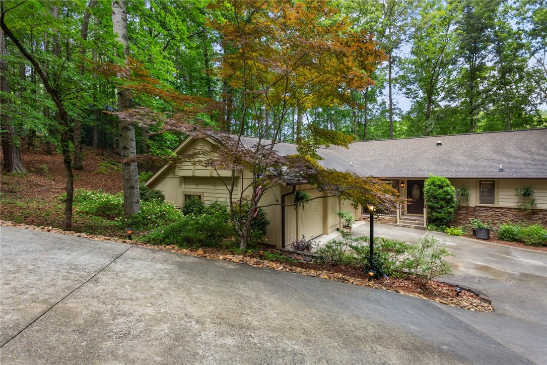 Image 1: A private wooded setting surrounds this inviting r