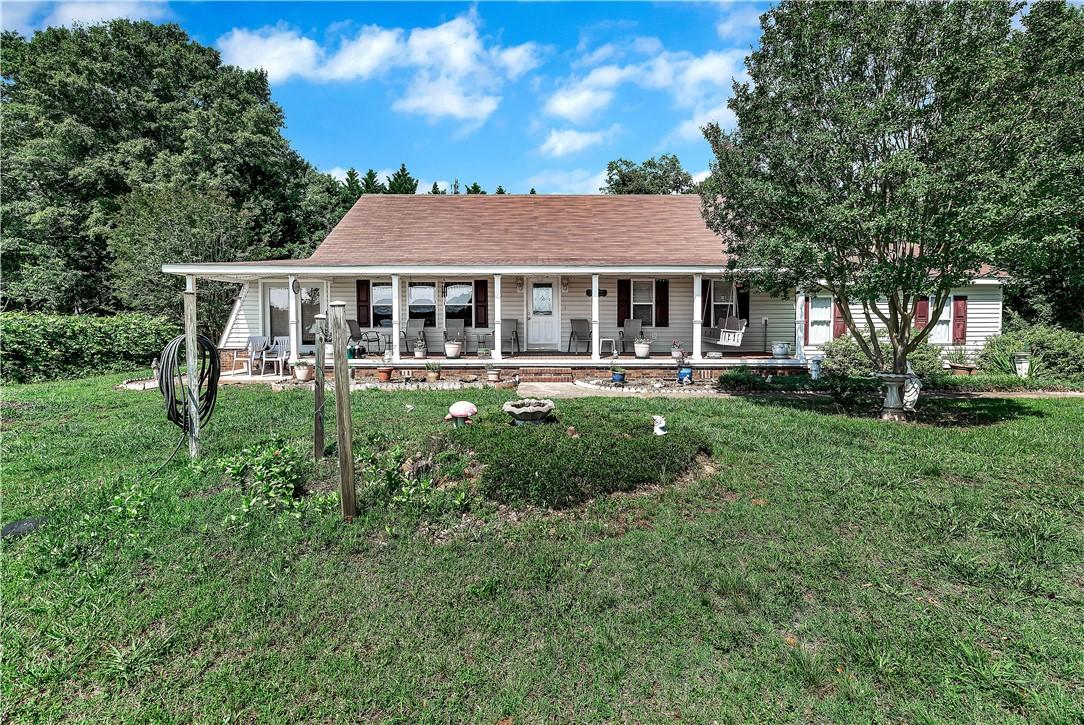 Image 1: A charming residence with a broad covered porch, i