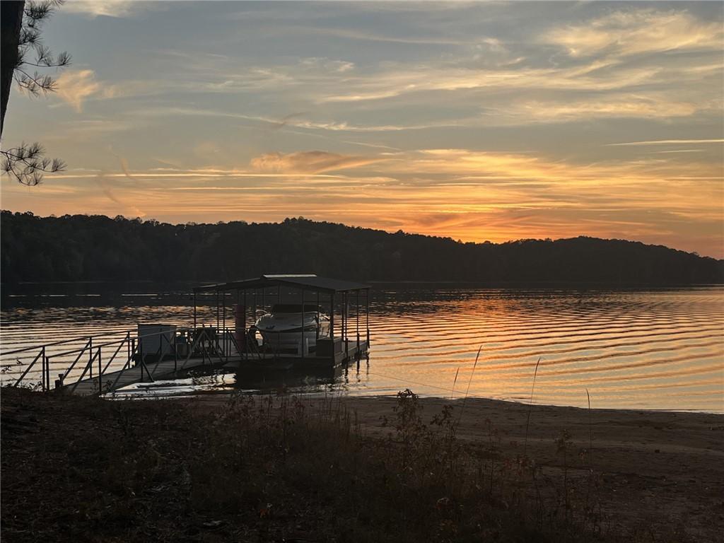Image 1: Golden hues paint the sky over a serene lake, feat