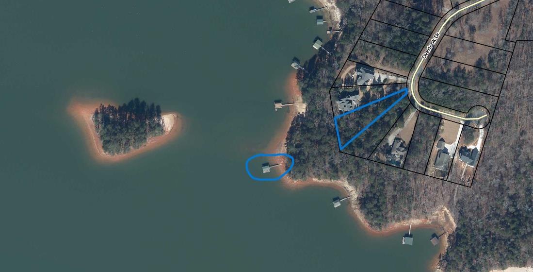 Image 2: A tranquil aerial view reveals a lush waterfront p