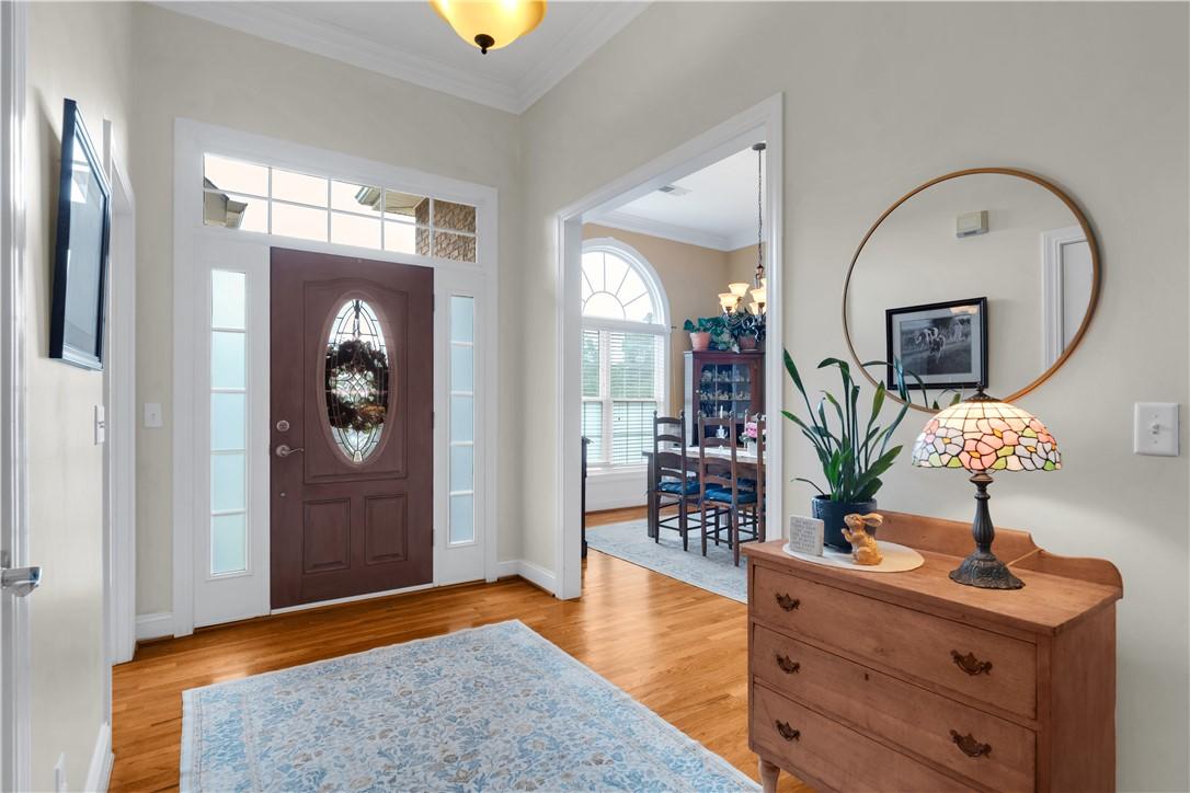 Image 2: A well-lit entry foyer with gleaming hardwood floo