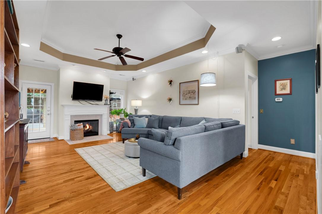 Image 3: A welcoming living area boasts rich hardwood floor