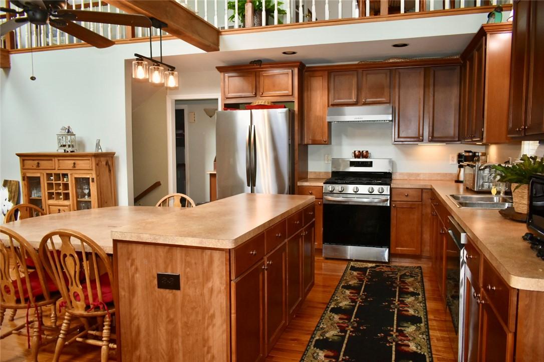 Image 4: A well-appointed kitchen features rich wood cabine