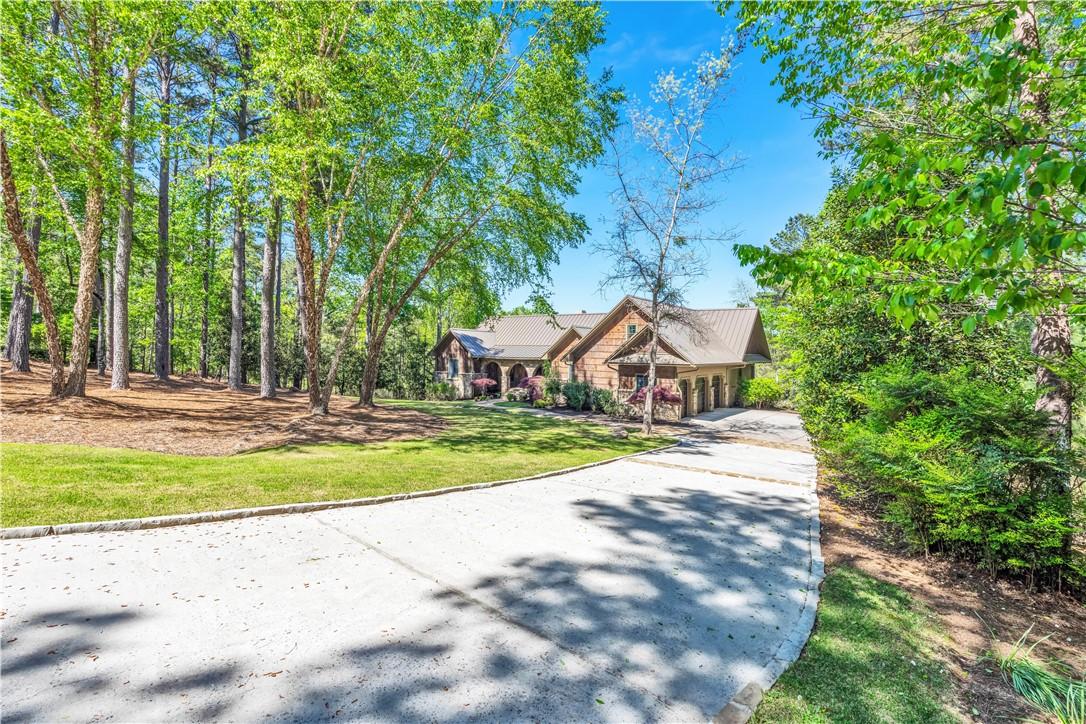 Image 3: This charming home features a long driveway leadin