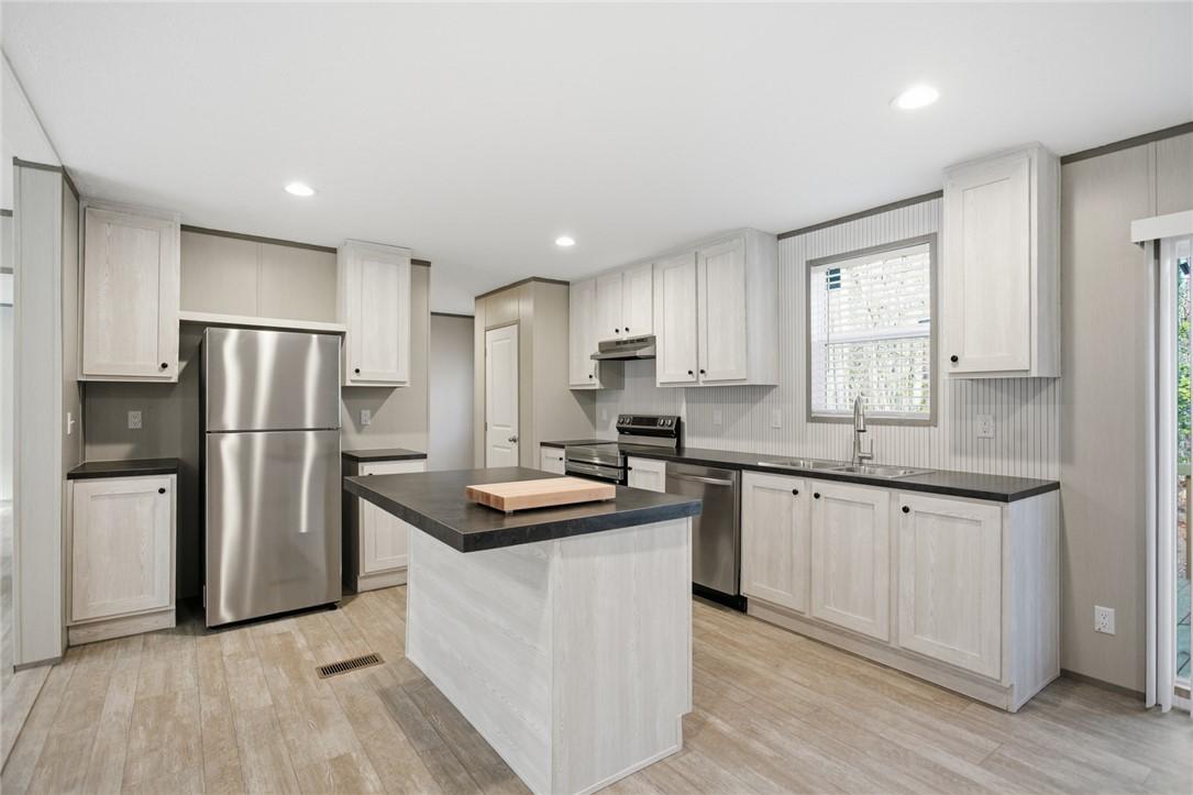 Image 3: This bright kitchen features an inviting island, a