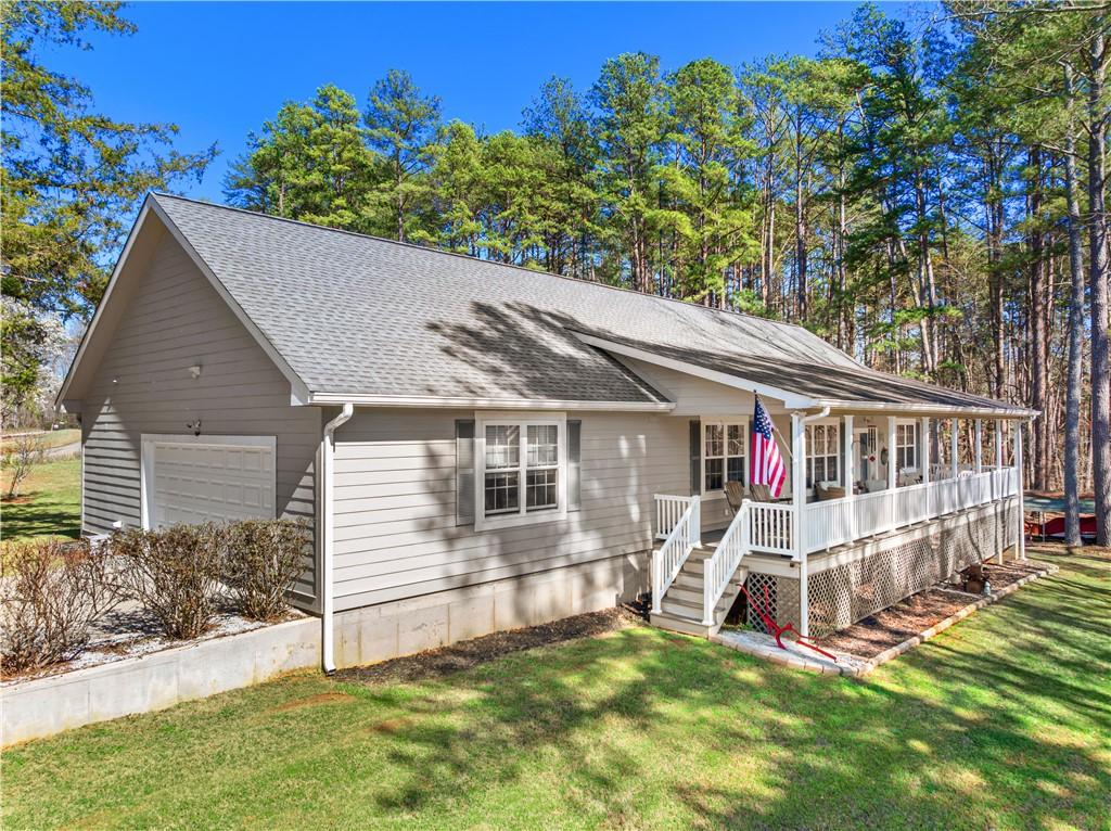Image 2: This charming home features a welcoming porch, gar