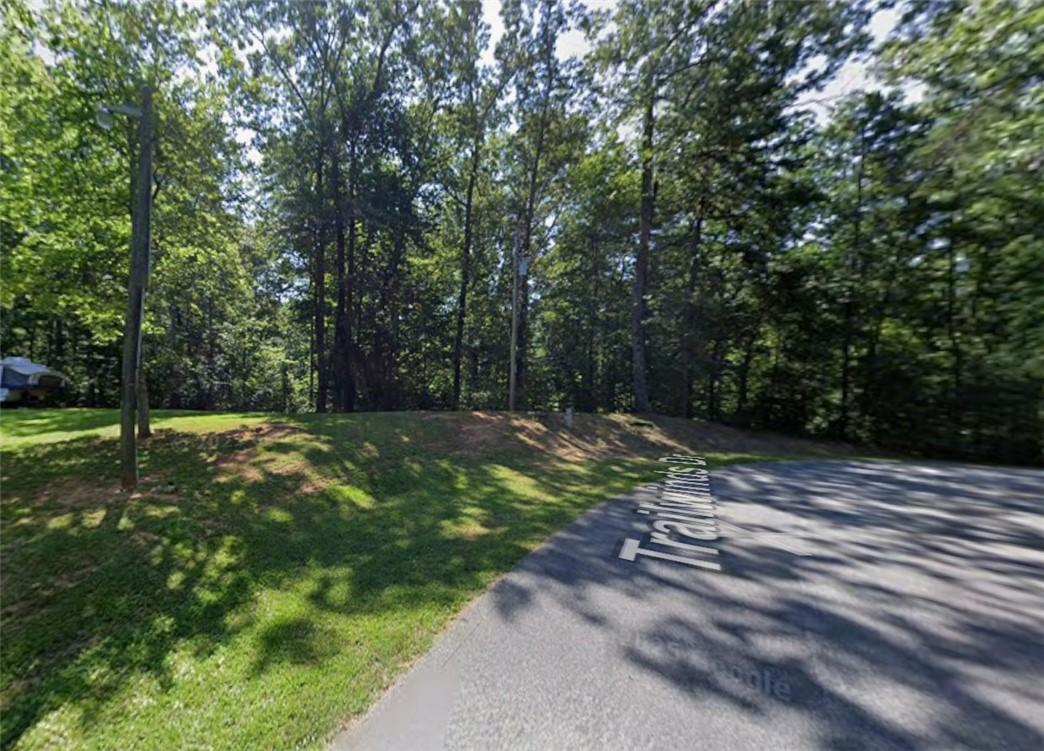 Image 2: A spacious, tree-lined lot offers an ideal setting