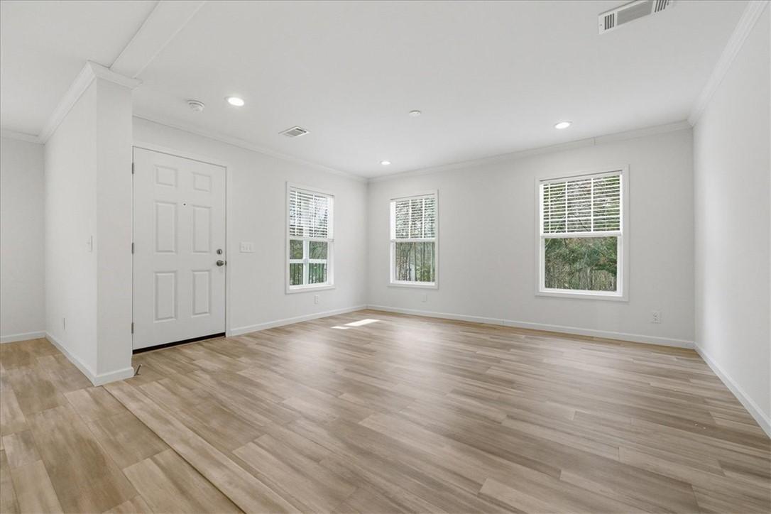 Image 3: This bright living space features elegant flooring