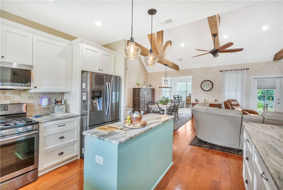 Image 4: An open-concept living area features a kitchen isl