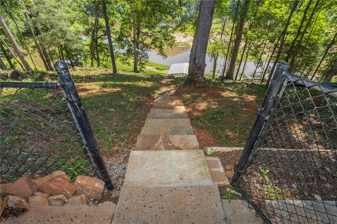 Image 4: Steps descend through a verdant landscape to a pri