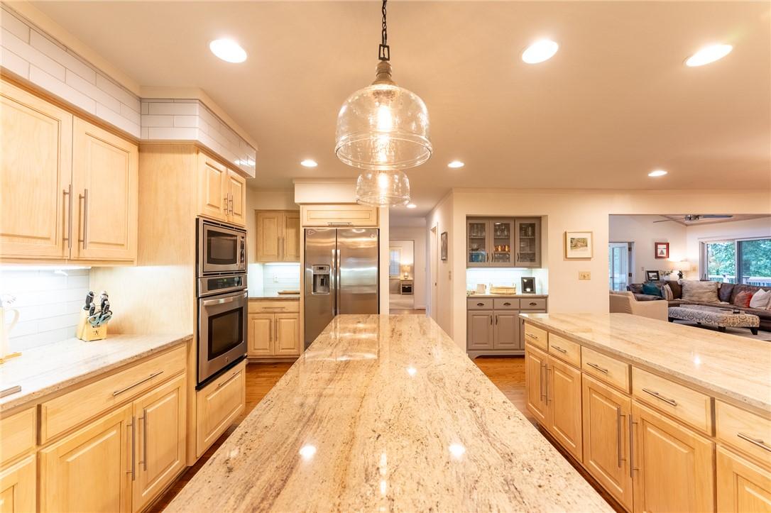 Image 3: An inviting open-concept kitchen features a substa