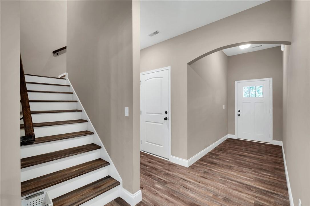 Image 4: This entry welcomes with rich wood flooring and a