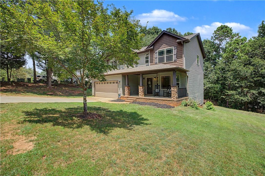 Image 2: A welcoming front porch with stone accents enhance