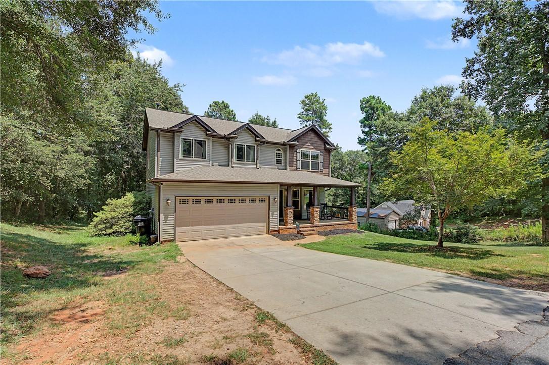 Image 3: A welcoming front porch and attached garage define
