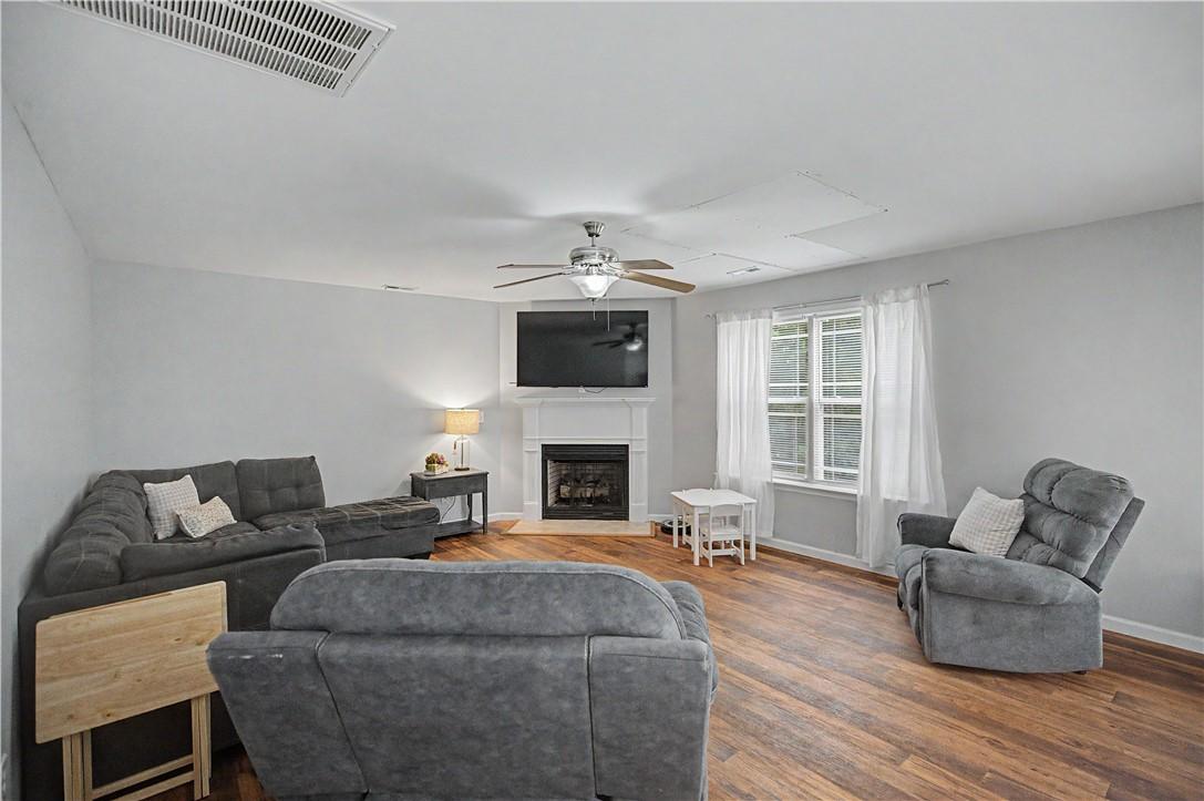 Image 4: Warm wood flooring extends throughout this living