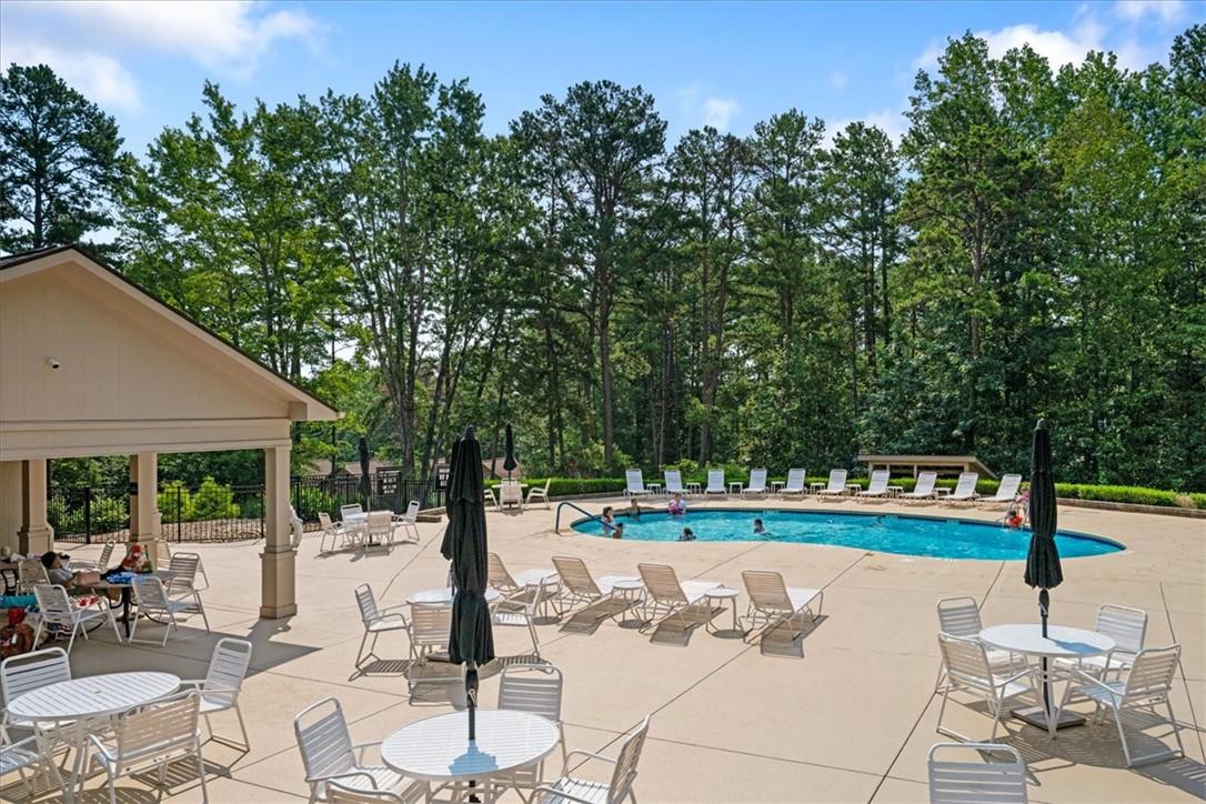 Image 4: An inviting pool area with ample seating and shade