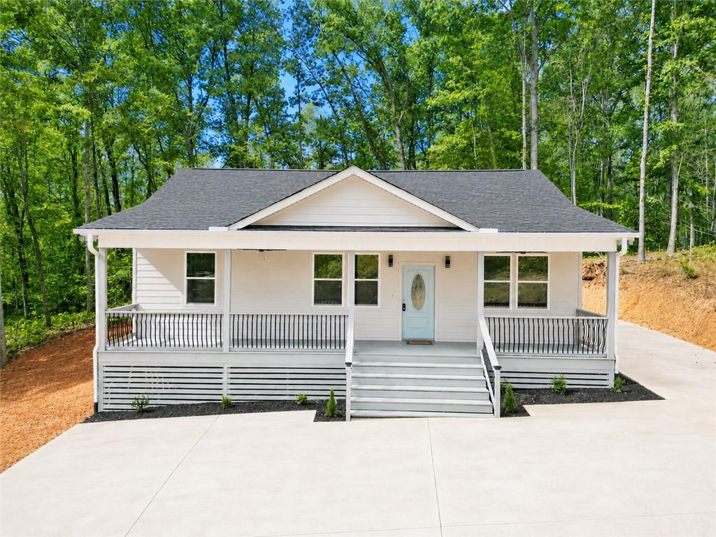 Image 1: A welcoming front porch with white siding and blac