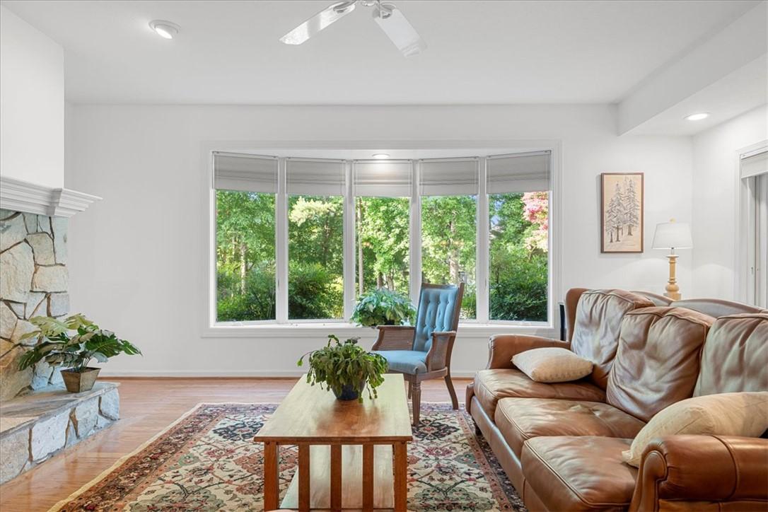 Image 3: This bright living area features a stone fireplace