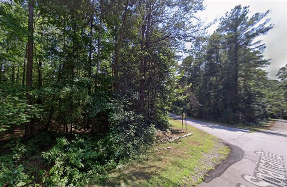 Image 1: Mature trees line the quiet street, offering a ser
