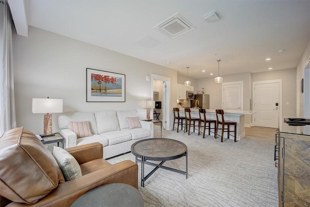 Image 2: An open concept living area boasts a modern kitche