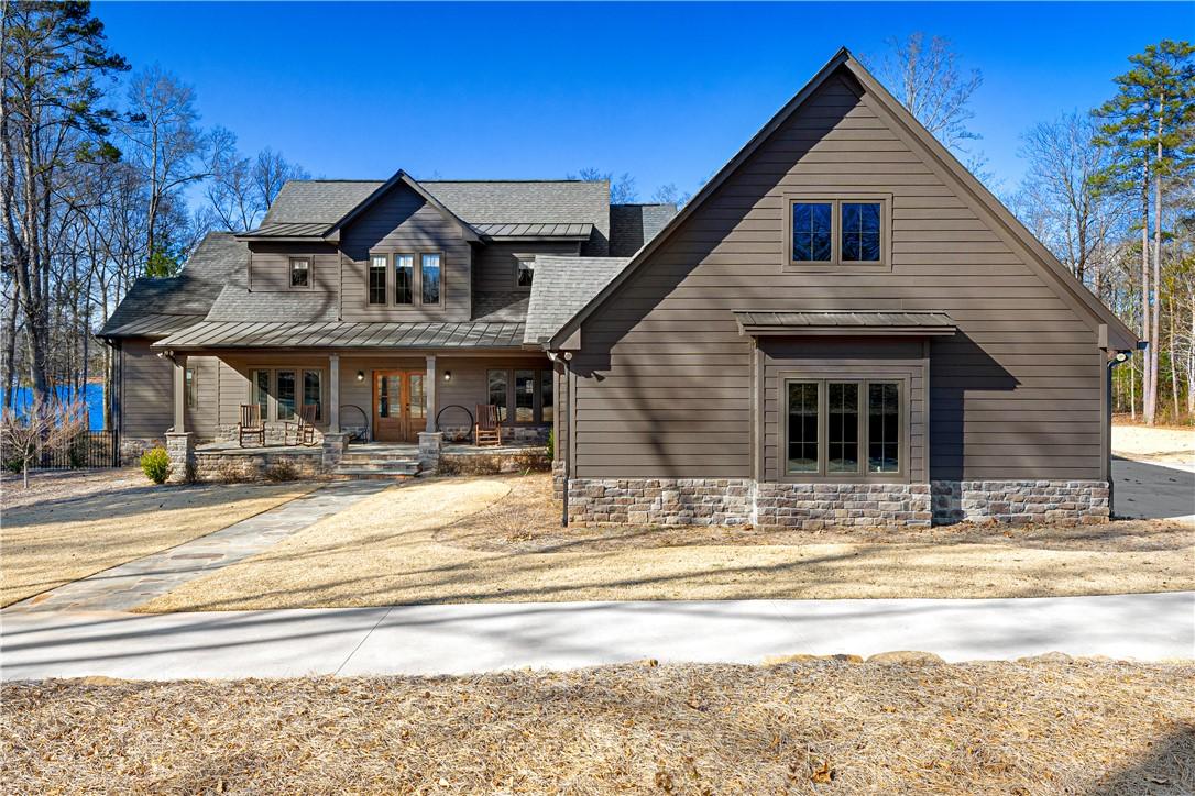 Image 1: This grand home with its inviting porch and stone