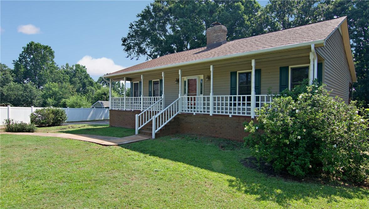 Image 3: A welcoming front porch with white railing offers