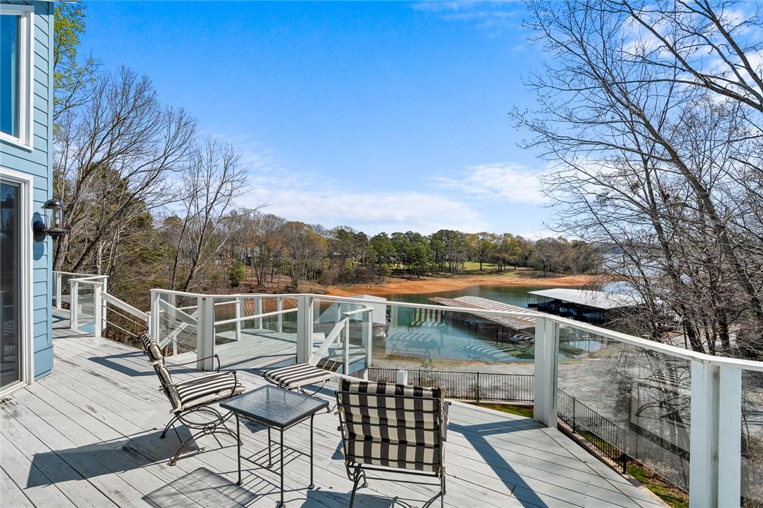 Image 4: This spacious deck overlooks serene waters and lus