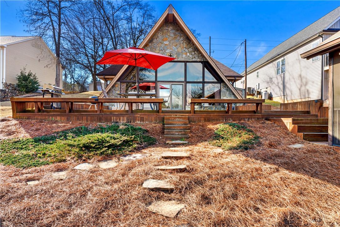 Image 1: This A-frame residence features a spacious deck, o