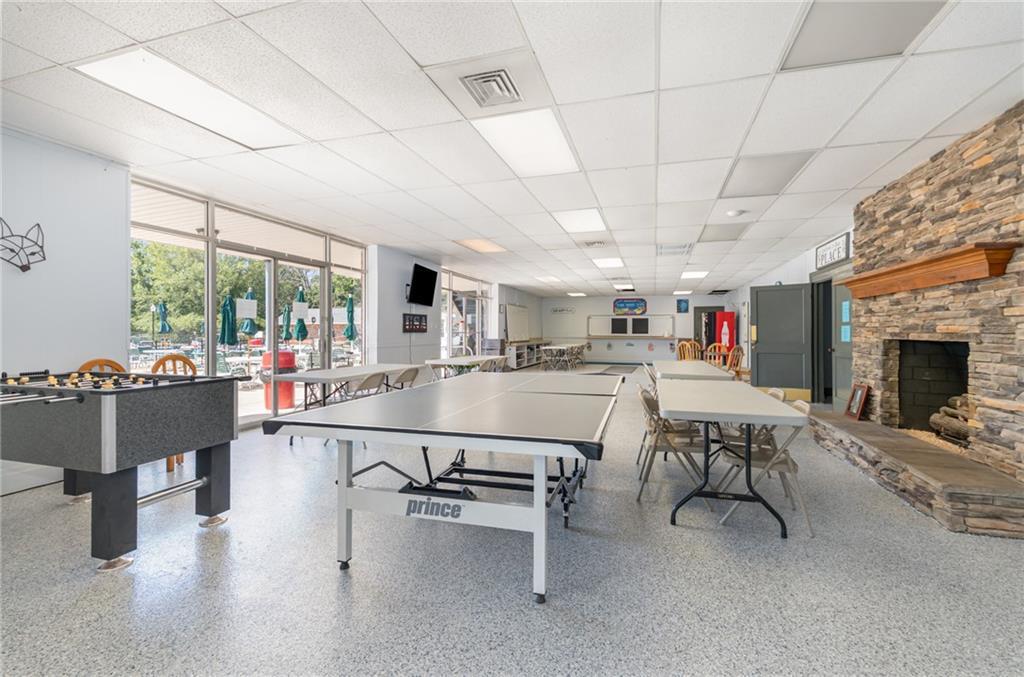 Image 3: This spacious recreation room features a stone fir
