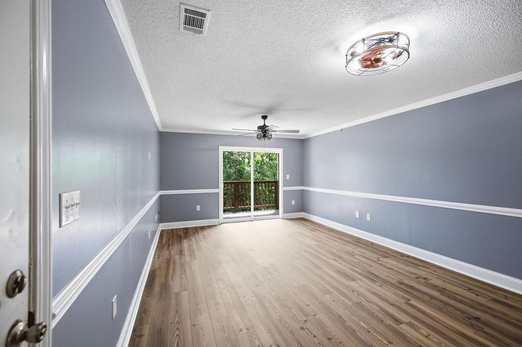 Image 3: A well-lit living space features rich hardwood flo