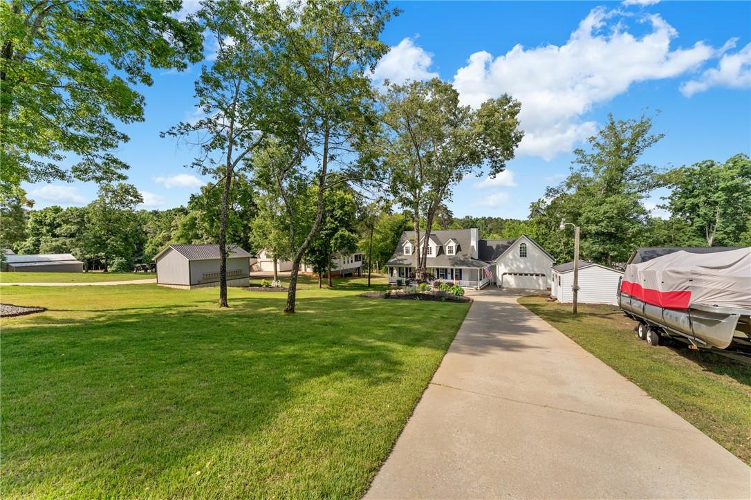 Image 3: A long, concrete driveway leads to a classic white