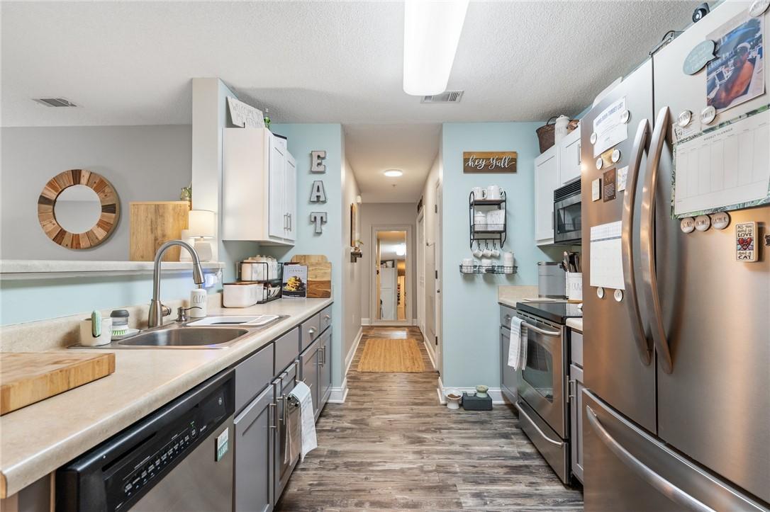 Image 4: A galley kitchen features contemporary appliances,
