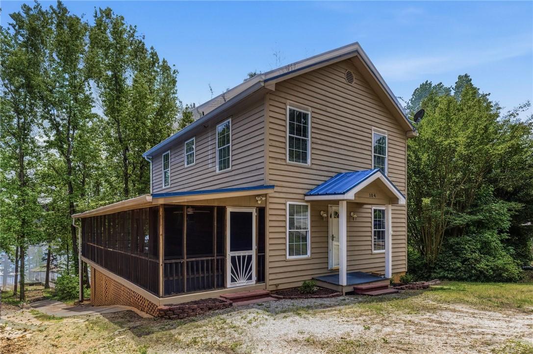 Image 2: This two-story home with a blue roof offers an exp