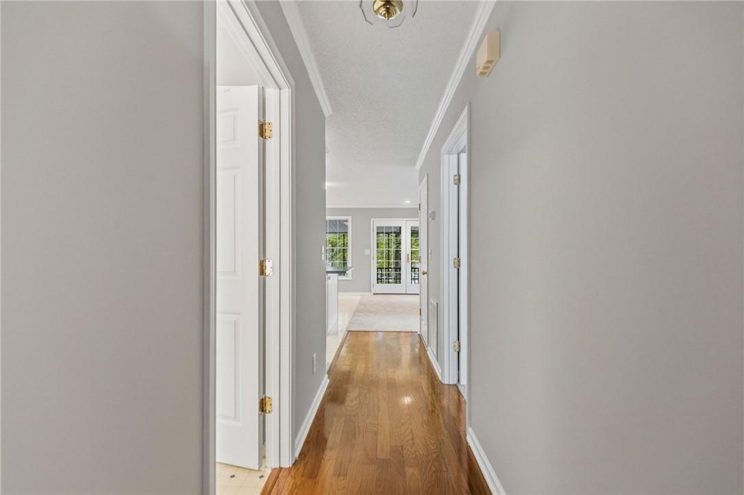 Image 3: This interior hallway features hardwood flooring a