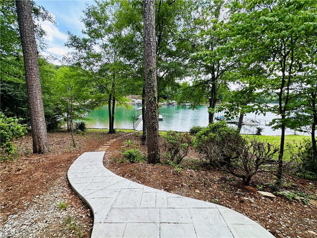 Image 2: A gentle paved path descends through lush greenery