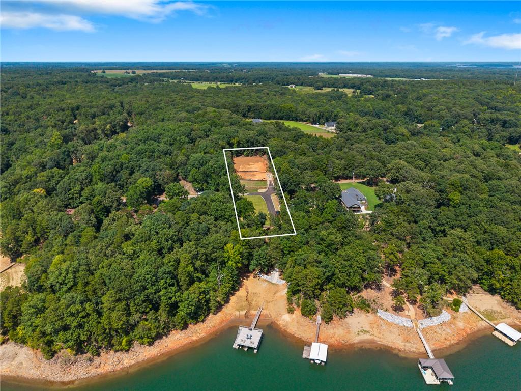 Image 4: A spacious, wooded lot offers an ideal setting for