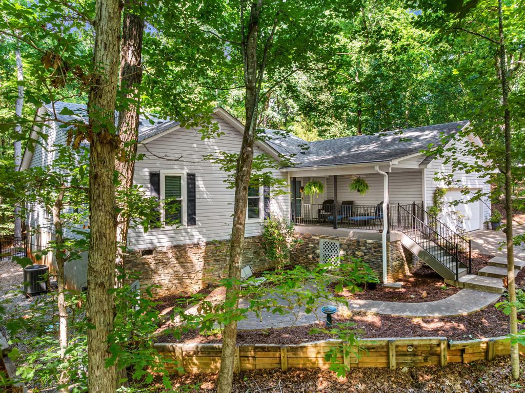 Image 1: Nestled among a verdant tree canopy, this home off