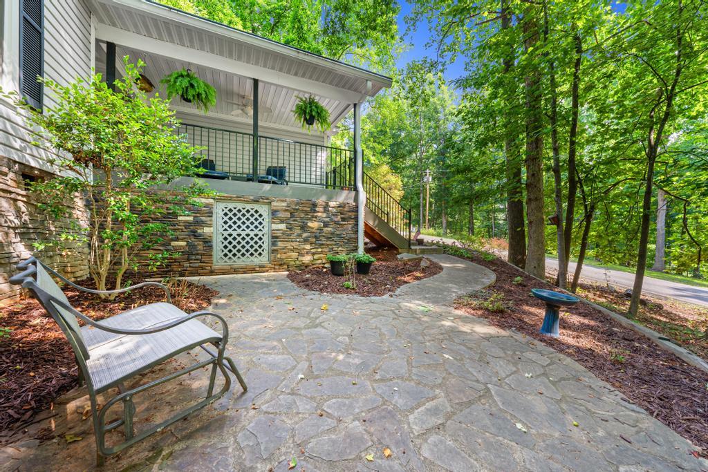 Image 3: A flagstone patio with a covered porch extends an