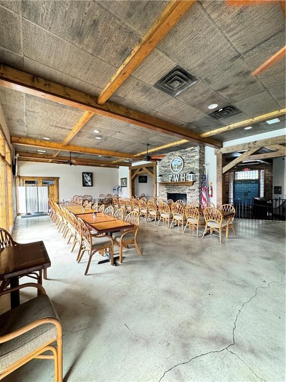 Image 3: This spacious hall boasts exposed wood beams, a st