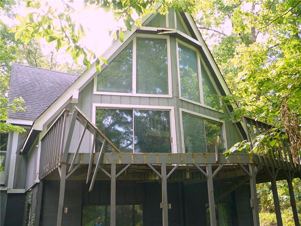 Image 1: Perched among verdant trees, this unique A-frame s