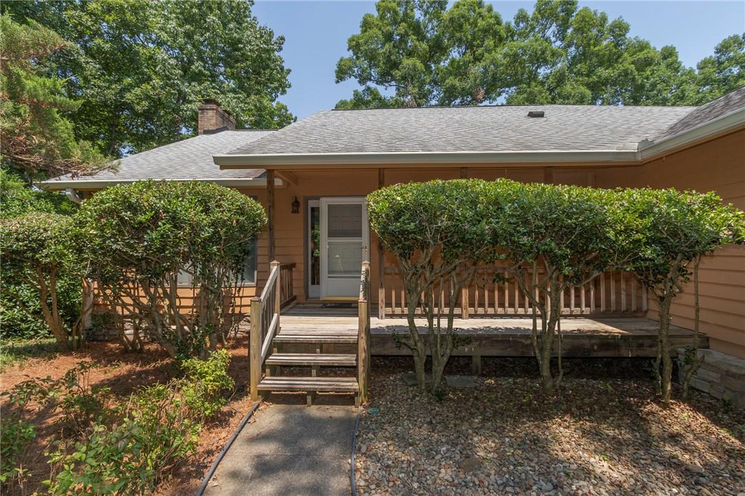 Image 2: A welcoming front porch leads to this charming res