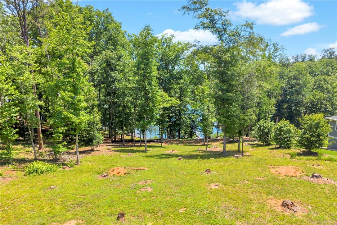 Image 1: A pristine lot with mature trees offers tranquil l