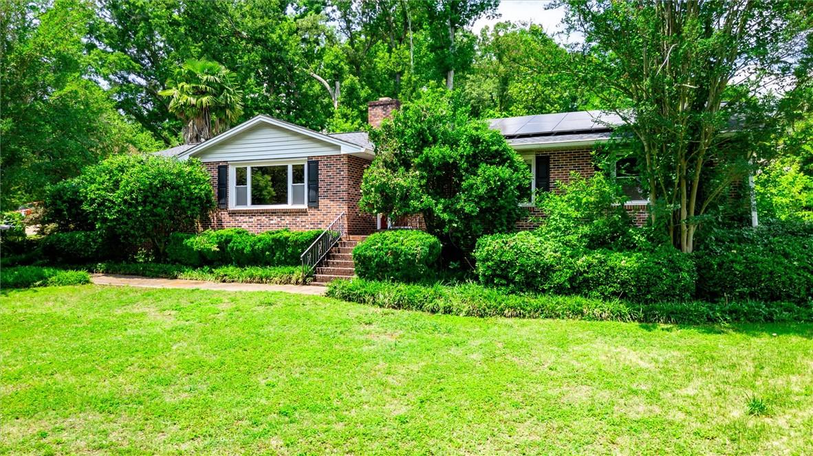 Image 1: A classic brick exterior with solar panels nestled