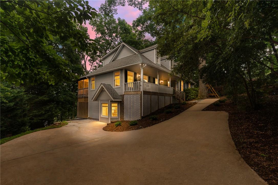 Image 1: A graceful home nestled among mature trees feature