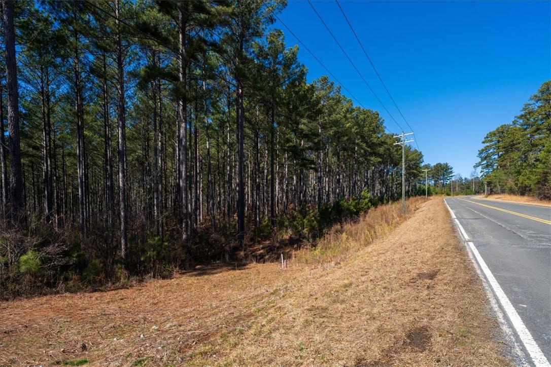 Image 2: Mature trees line this expansive lot, offering a s