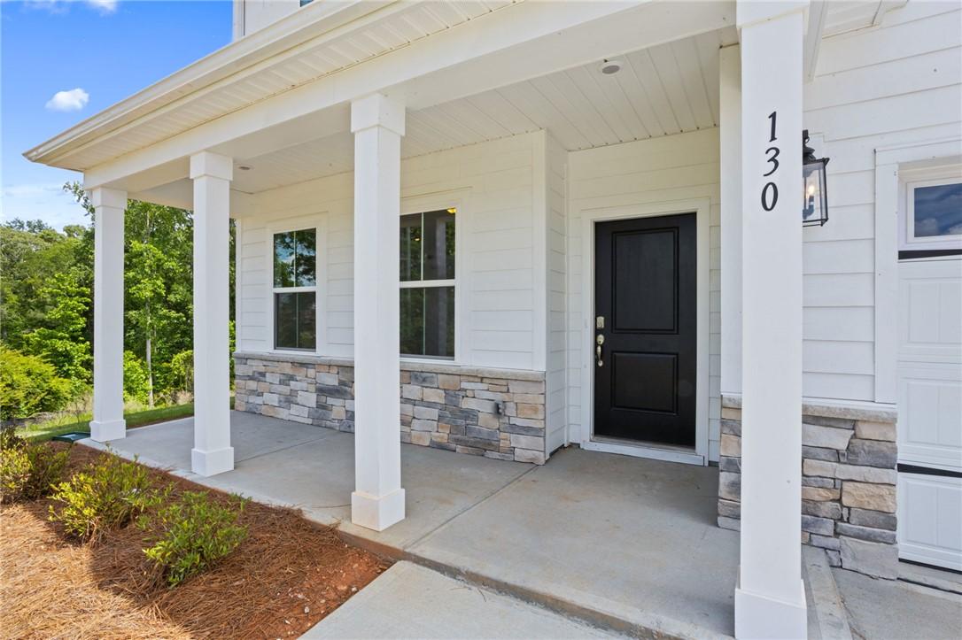 Image 3: A welcoming front porch with stone accents provide